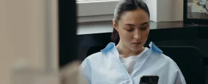 A clinician checking an order on a phone in a treatment room
