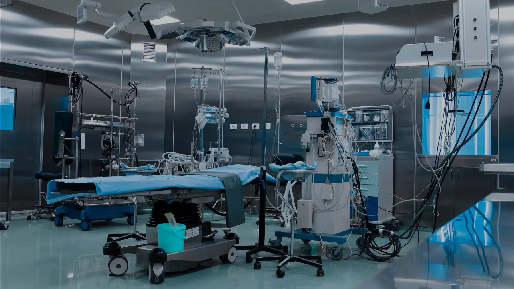 An operating theatre prepared for a procedure, with anaesthesia and patient monitoring equipment beside the table